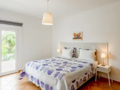 a white bedroom with a bed and a window at Villa Villa Pescada by Interhome in Albufeira