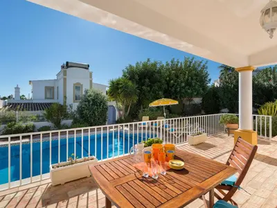 a wooden table on a patio with a swimming pool at Villa Villa Natura by Interhome in Guia