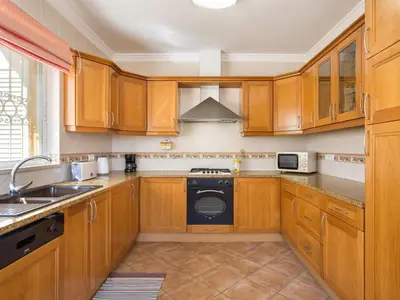 a kitchen with wooden cabinets and a dishwasher at Villa Villa Natura by Interhome in Guia