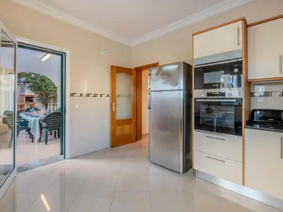 a kitchen with a stainless steel refrigerator and a table at Villa Colibri by Interhome in Patroves