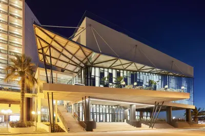 a large building with a glass facade at night at Tivoli Marina Vilamoura in Vilamoura