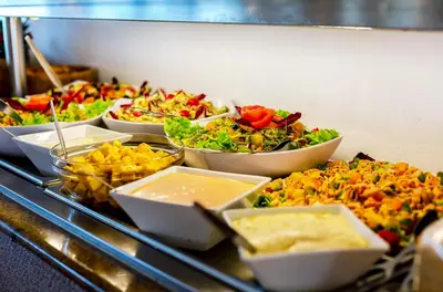 a buffet with several trays of food on a table at Monica Isabel Beach Club in Albufeira