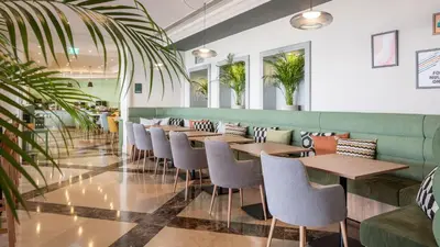 an empty restaurant with tables and chairs at Holiday Inn Algarve Albufeira by IHG in Albufeira
