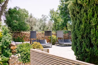 a patio with a couch and some flowers and an umbrella at Casa do Alto in Vilamoura