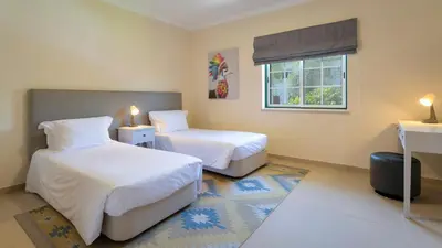 a bedroom with two beds and a window at Martinhal Quinta Family Resort in Quinta do Lago