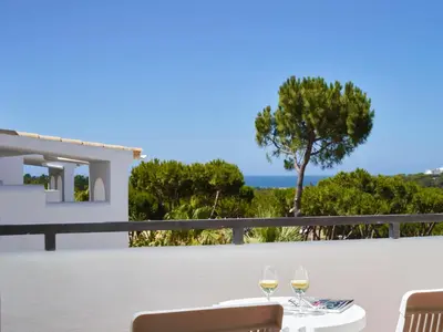 a table with two glasses of wine on a balcony at Ria Park Garden Hotel in Vale do Lobo