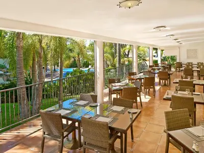 a restaurant with tables and chairs and a balcony at Ria Park Garden Hotel in Vale do Lobo