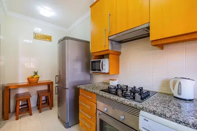 a kitchen with a stove and a stainless steel refrigerator at Pool&Beach in Encosta de São José in Albufeira