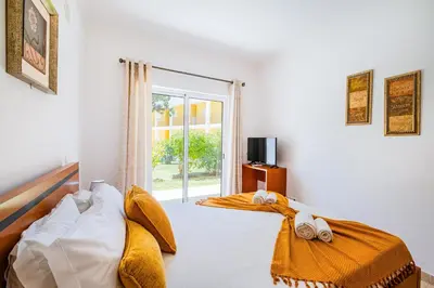 a bedroom with a bed with yellow sheets and a window at Pool&Beach in Encosta de São José in Albufeira