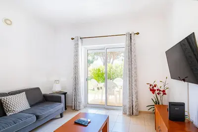 a living room with a couch and a sliding glass door at Pool&Beach in Encosta de São José in Albufeira