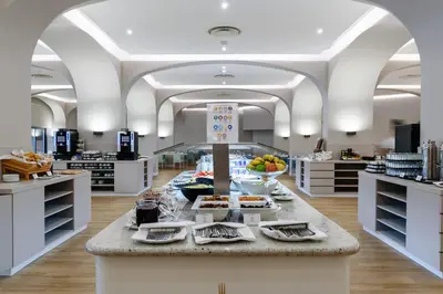 a buffet in a store with food on a counter at Jupiter Albufeira Hotel - Family & Fun - All Inclusive in Albufeira