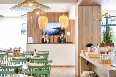 a restaurant with green chairs and a woman in the mirror at Clube Maria Luisa in Albufeira