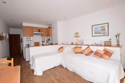 two white beds in a room with a kitchen at Cosy and Sweet Apartment in Albufeira in Albufeira
