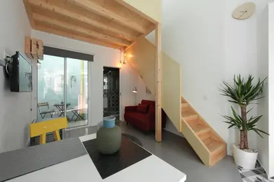 a living room with a staircase and a red couch at DUBOCAGE43 Citycenter in Faro
