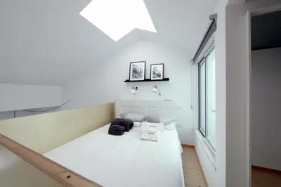 a bedroom with a white bed in a room with a window at DUBOCAGE43 Citycenter in Faro