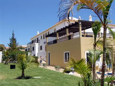 a restaurant with tables and chairs and palm trees at night at Apartamentos Turisticos Novochoro in Albufeira
