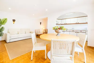 a living room with a table and a tv at Apartamentos Turisticos Novochoro in Albufeira