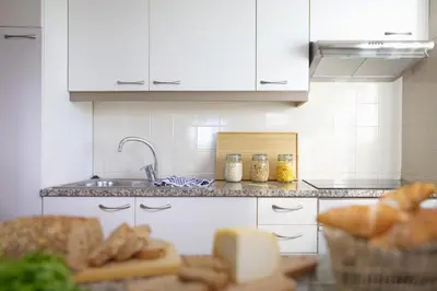 a kitchen with a counter with bread and a sink at Cegonha Country Club in Vilamoura
