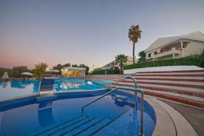 a swimming pool with stairs next to a house at Cegonha Country Club in Vilamoura