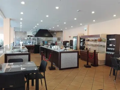 a kitchen with tables and chairs in a restaurant at Hotel Balaia Mar in Albufeira