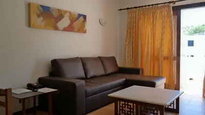 a living room with a couch and a table at Apartamentos da Balaia in Albufeira