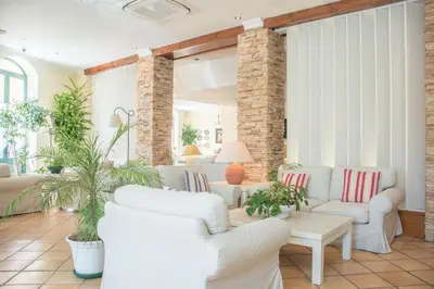 a living room with white furniture and plants at Loule Jardim Hotel in Loulé