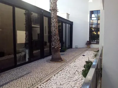 a palm tree in the courtyard of a building at Alisios in Albufeira