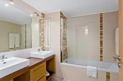 a bathroom with a sink and a tub and a mirror at Prado Villas in Vilamoura