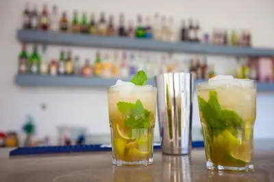 two cocktails with mint on a table in a bar at Vila Recife Hotel in Albufeira