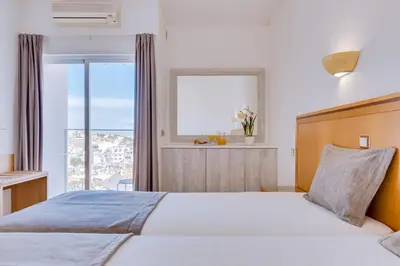 a bedroom with a large bed and a window at Vila Recife Hotel in Albufeira