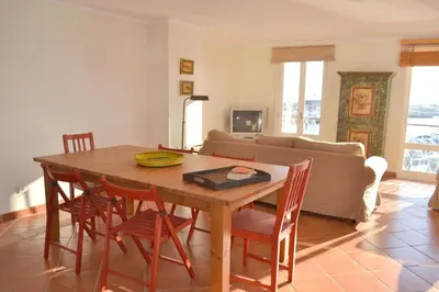 a living room with a wooden table and chairs at TP Aqua Marina, Vilamoura Triplex Apartment in Quarteira