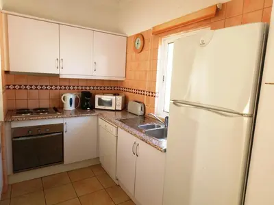 a kitchen with white cabinets and a white refrigerator at Prado do Golf in Vilamoura