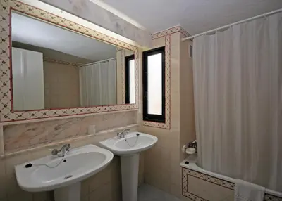 a bathroom with a sink and a mirror and a shower at Prado do Golf in Vilamoura