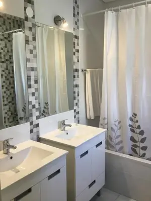 a bathroom with two sinks and a shower curtain at Prado do Golf in Vilamoura