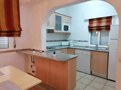 a kitchen with an archway over a kitchen counter at Prado do Golf in Vilamoura