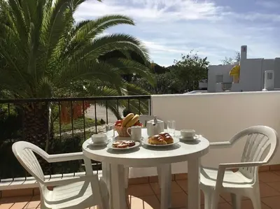 a white table and chairs with food on a balcony at Prado do Golf in Vilamoura