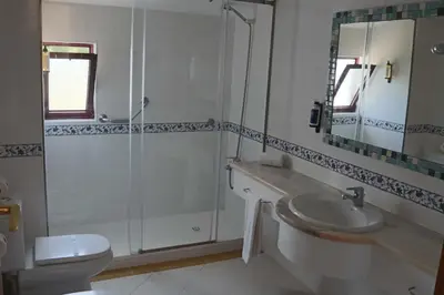 a bathroom with a shower and a sink and a toilet at Hotel Apartamento Do Golfe in Vilamoura