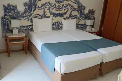 a bedroom with a large bed with two night stands at Hotel Apartamento Do Golfe in Vilamoura
