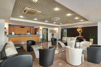 a lobby with black and white chairs and a counter at Hotel Apartamento Do Golfe in Vilamoura