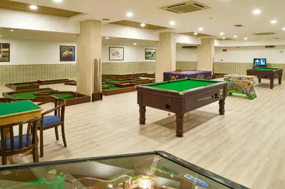 a room with billiard tables and chairs in a room at Hotel Apartamento Brisa Sol in Albufeira