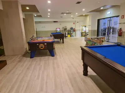 a gym with two pool tables in a room at Hotel Apartamento Brisa Sol in Albufeira
