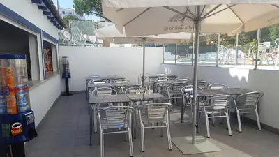 a row of tables and chairs with umbrellas in a restaurant at Apartamentos Turisticos Soldoiro in Albufeira