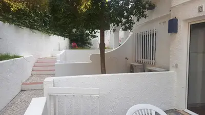 a white house with a white fence and stairs at Apartamentos Turisticos Soldoiro in Albufeira