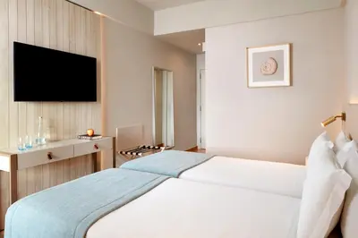 a hotel room with a bed and a flat screen tv at Dom Jose Beach Hotel (Plus) in Quarteira