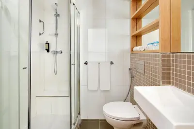 a bathroom with a shower and a toilet and a sink at Dom Jose Beach Hotel (Plus) in Quarteira