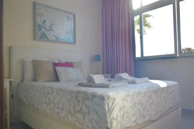 a white bedroom with a bed with a window at Vilamoura-Nautic Apartment in Vilamoura