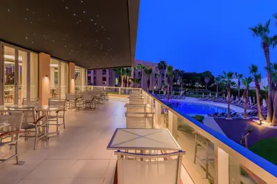a hotel patio with tables and chairs and a swimming pool at NAU Sao Rafael Suites - All Inclusive in Albufeira