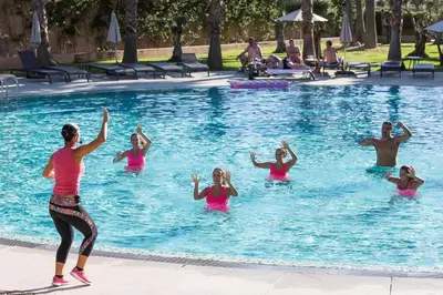 a group of people doing yoga in a swimming pool at NAU Sao Rafael Suites - All Inclusive in Albufeira