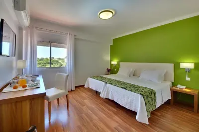 a bedroom with a bed and a green wall at Zodiaco in Quarteira