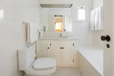 a white bathroom with a toilet and a sink at Balaia Golf Village in Albufeira